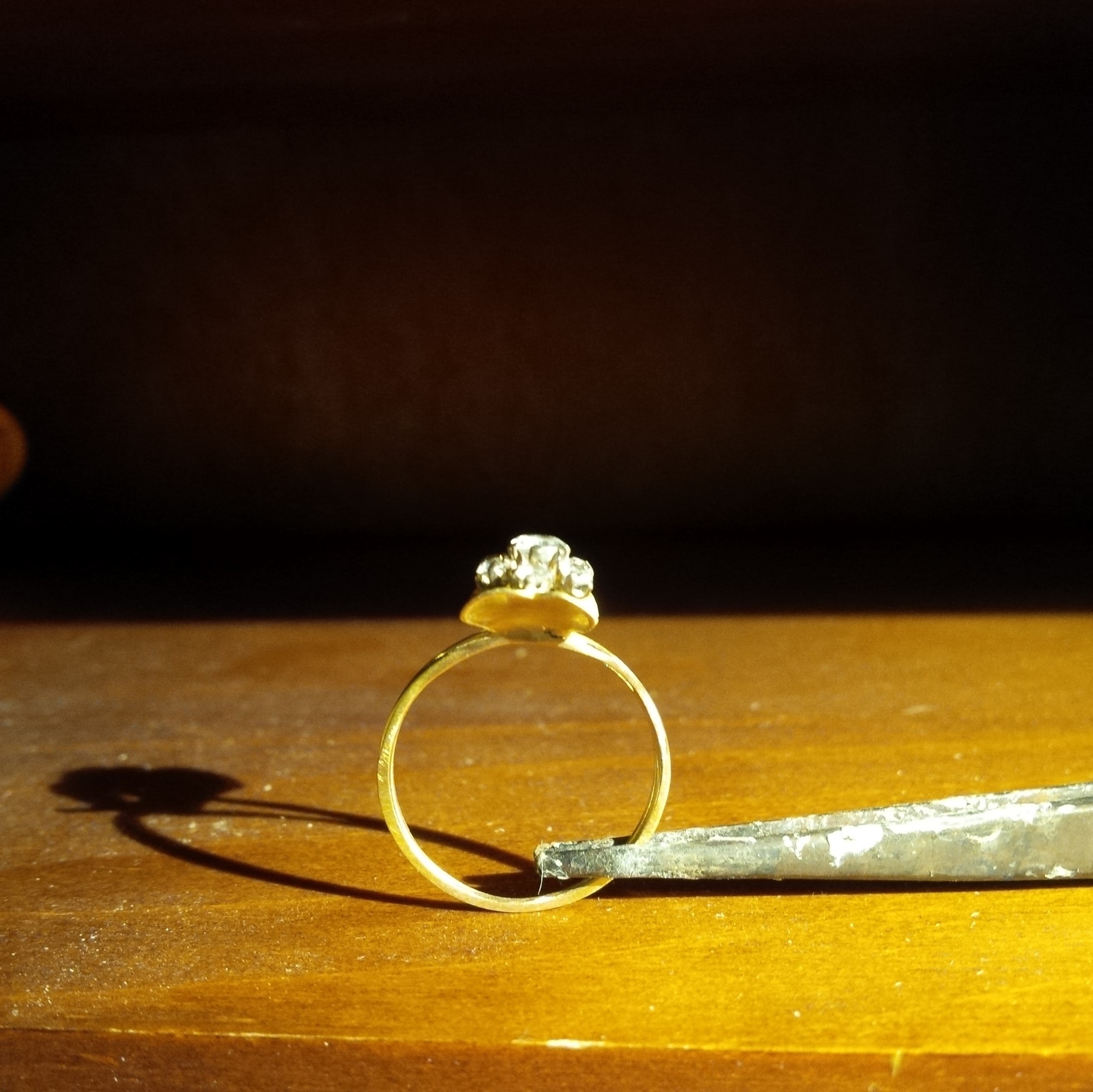 Bague en or et diamants posée sur l’établi